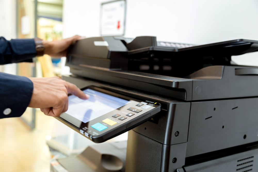 Hand press button on panel of printer, printer scanner laser office copy machine supplies start concept.
